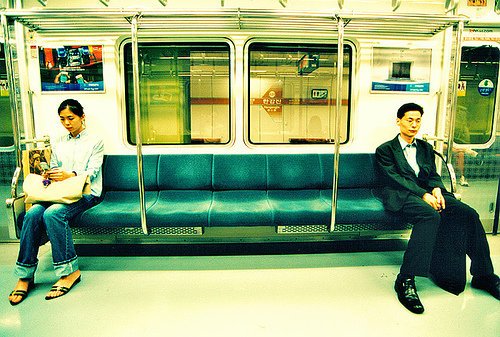korean-man-and-woman-sitting-apart-on-subway
